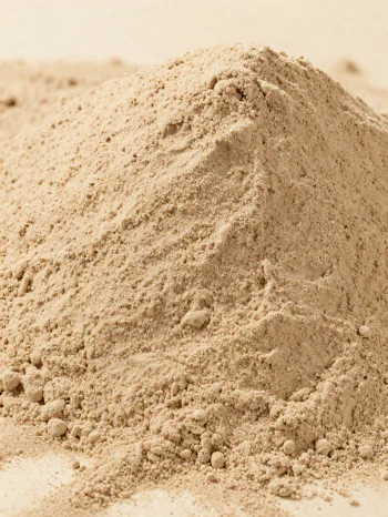Farinha de castanha marrom clara em tigela rústica, espalhada em superfície de madeira