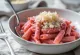 Macarrão prebiótico com beterraba e alho-poró, massa fusilli tingida de rosa intenso misturada com tiras de alho-poró