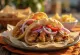 Carne de gyros recém-frita no pão pita, servida com vegetais e molho de iogurte.