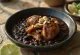 Mole prieto servido com frango, creme de leite e amêndoas