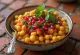 Ghugni chaat de ervilha amarela, servido com folhas de coentro frescas e chutney de tamarindo