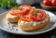 Bagel com tomate e cream cheese, decorado com manjericão