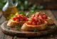 Bruschetta com tomate e manjericão servida em um prato rústico