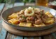 Beshbarmak com carne de cavalo, servido com salsinha fresca e cebolinha