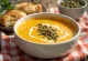 Sopa creme de abóbora com sementes tostadas servida