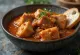 Ensopado de carne suína servido com batatas e salsinha fresca